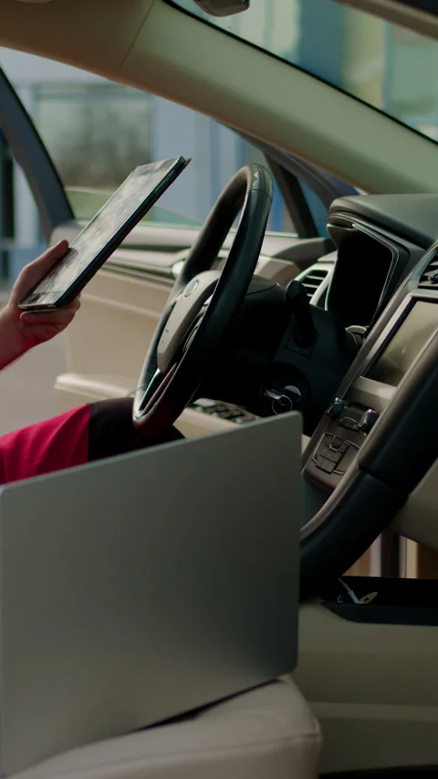 Mechanic in red overalls working inside vehicle, using computer to diagnose Stock Footage 320394118