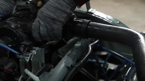 Mechanic remove the fuel pipe, filter from under the hood space of the car Stock Footage 156385247