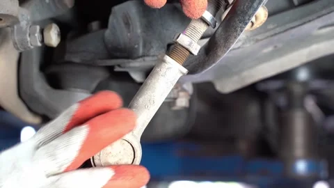 The mechanic is removing the ball joint. Pulling the ball joint out of the c Stock Footage 243370026