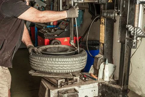 Mechanic removing leads from wheel using electric tools Stock Photos