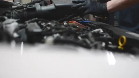 Mechanic removing the old air filter from a car and inspecting it Stock Footage 132304030