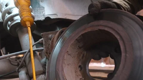 Mechanic removing an old rusty brake disc rotor Stock Footage 326141816