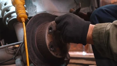 Mechanic removing old rusty car brake disc Stock Footage 326141937