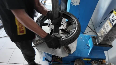 A mechanic is removing an outer tire using a machine Stock Footage 292818624