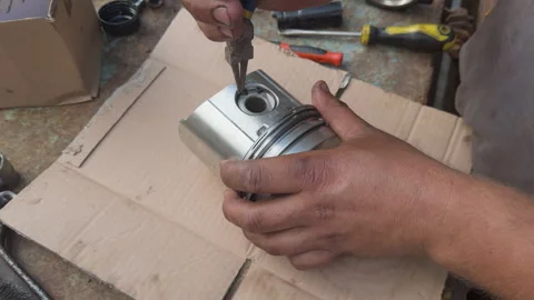 Mechanic removing piston pin circlip with pliers Stock Footage 338410907