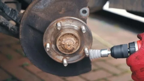 Mechanic removing rust from car wheel hub with rotating wire brush tool. Close Vídeo Stock 338389078