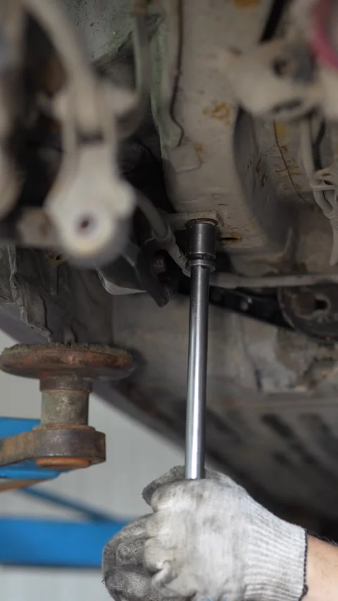 Mechanic Removing Rusty Brake Disc from Car Wheel Hub using Socket Wrench Stock Footage 345564266