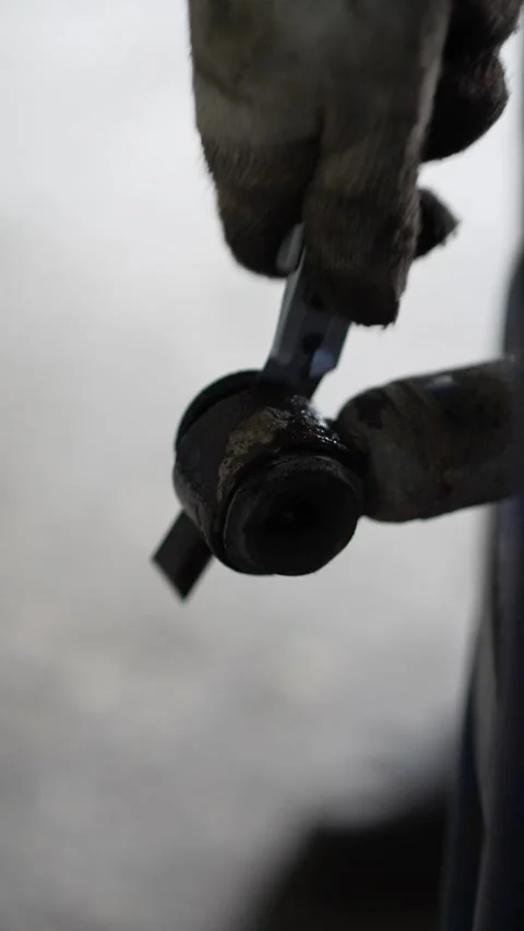 Mechanic Removing Rusty Suspension Control Arm Bolt from Car Wheel Hub Stock Footage 345568228