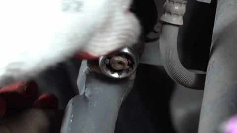 The mechanic is removing the upper control ball joint nut. Video stock 244232163