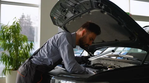 Mechanic repairing car engine under hood with work light Stock Footage 300613481