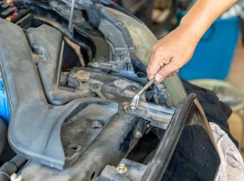 Mechanic repairing a car engine using a wrench to tighten bolts on the vehi.. Stock Photos