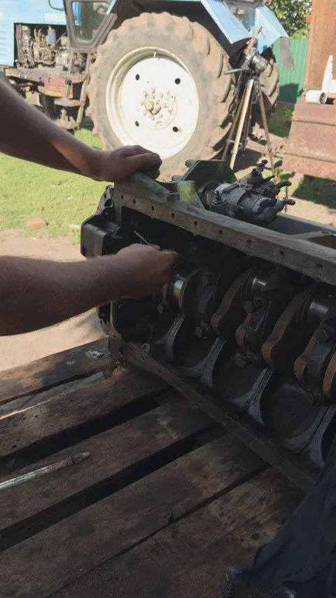 Mechanic repairing disassembled tractor engine outdoors Stock Footage 338410722