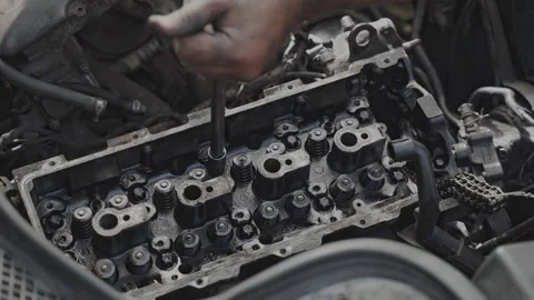 A mechanic is repairing an engine at an automobile workshop with precision and Video stock 279916244