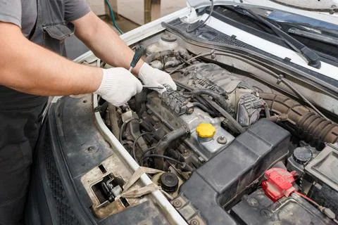 Mechanic repairing engine on a car using wrench. Close up of hands Stock Photos