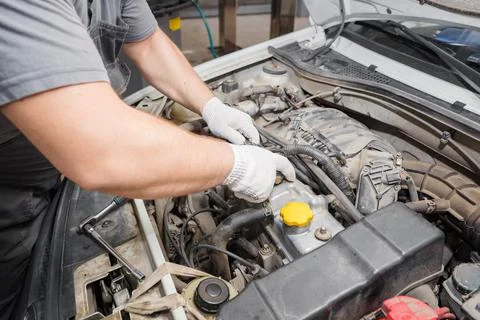 Mechanic repairing engine on a car using wrench. Close up of hands Stock Photos