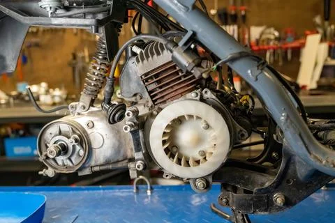 Mechanic repairing motorcycle engine in workshop Stock-Fotos