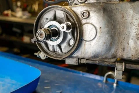 Mechanic repairing motorcycle engine in workshop: replacing the final drive Stock Photos
