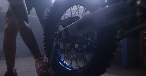 Mechanic repairing motorcycle by using open ended wrench in shop Stock Footage 116362196