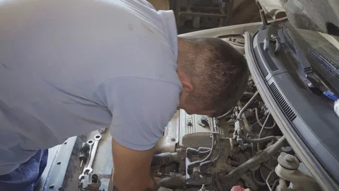 A mechanic repairs a car engine Stock Footage 126150956