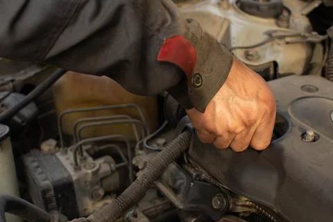 Mechanic repairs car engine, hand of master Stock Photos