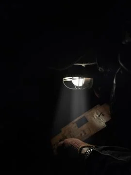 A mechanic repairs a part with a flashlight Stock Photos