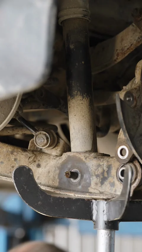 Mechanic repairs rusty car rear suspension with coil spring undercarriage Stock Footage 337569570