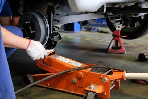 Mechanic replace shock absorber &amp; spring in auto repair garage Fotos de archivo