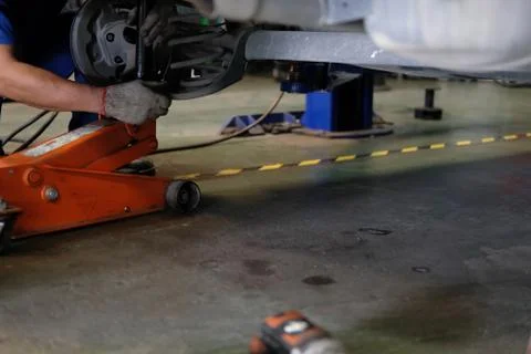 Mechanic replace shock absorber &amp; spring in auto repair garage Fotos de archivo