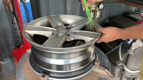 Mechanic replace tires on wheels in a workshop Stock Footage 166457224