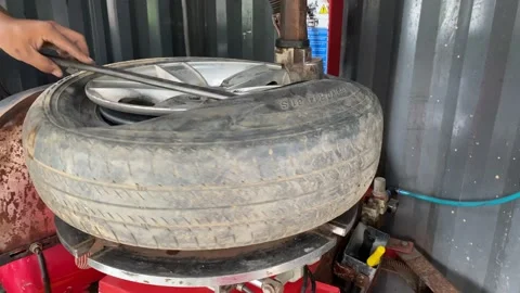 Mechanic replace tires on wheels in a workshop Stock Footage 166457251