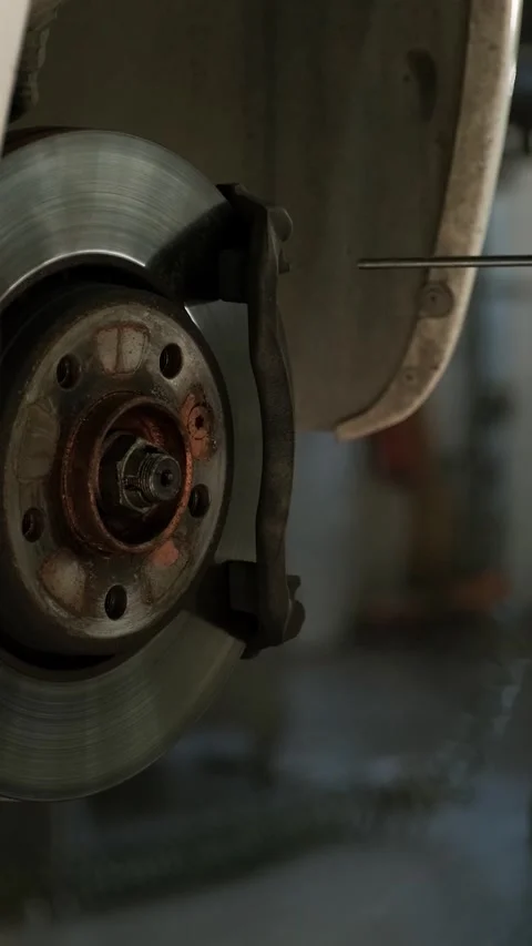Mechanic replacing brake disc and pads on car in garage Stock Footage 332858365