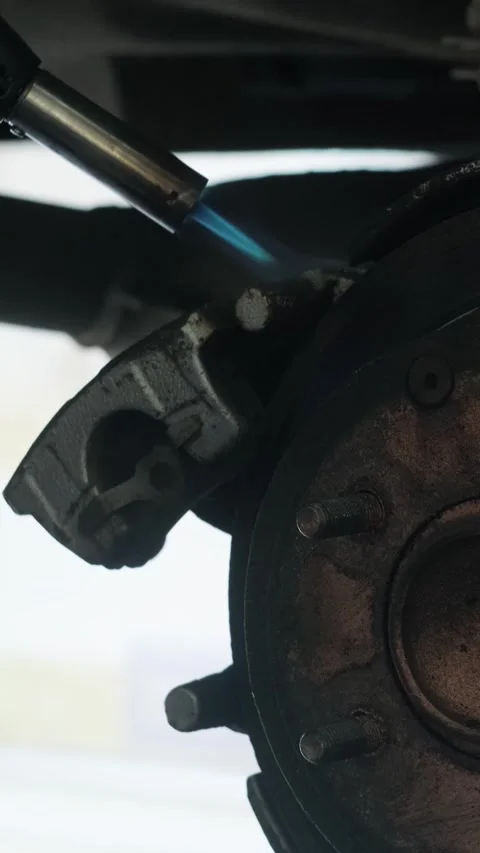 Mechanic replacing brake disc and pads on car in garage Stock Footage 332858422