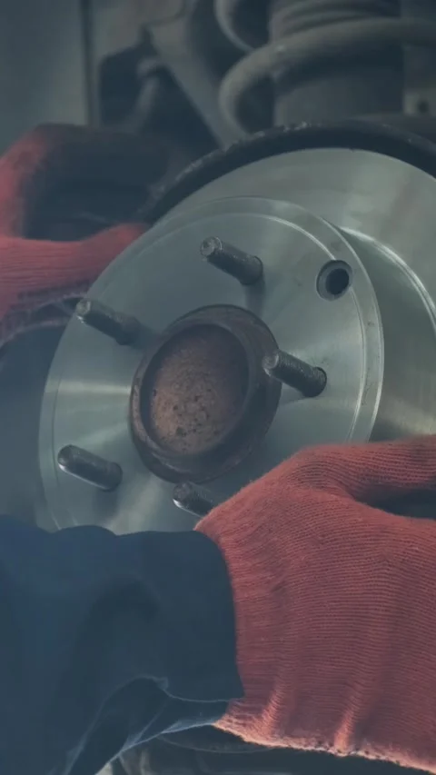 Mechanic replacing brake disc and pads on car in garage Stock Footage 332858427