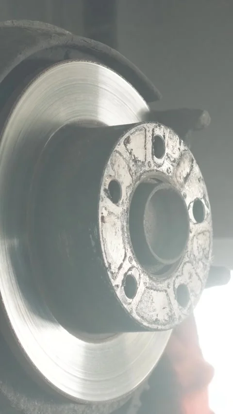 Mechanic replacing brake disc and pads on car in garage Stock Footage 332858544