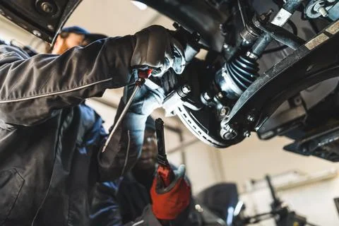 Mechanic replacing car wheel using different modern tools in car repair station Foto stock