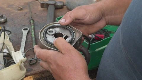 Mechanic replacing gasket on an engine oil cooler Stock Footage 339038309