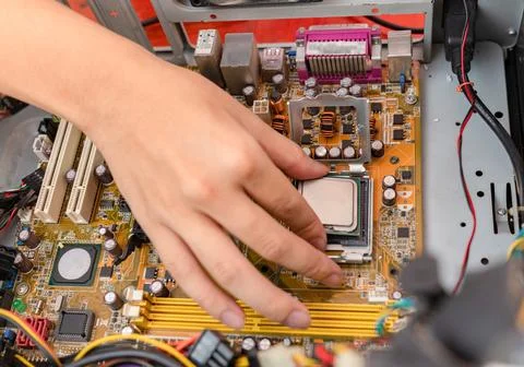 Mechanic replacing a new CPU instead of the old one over heat Stock Photos