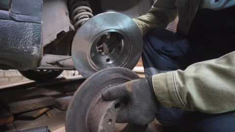 Mechanic replacing old car brake disc with new spare part Vidéo 326141991