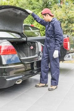 Mechanic replacing to the spare tire at the back of the car Stock Photos