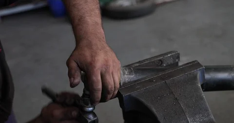 Mechanic replacing universal cross joint in cardan, uses vises to fix the cardan Video stock 103373397