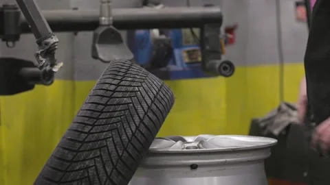 Mechanic replacing winter tyre on wheel rim 库存影片 294429042