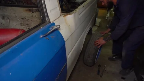 Mechanic rolls the wheel aside Stock Footage 80928298