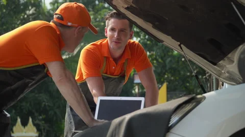 Mechanic senior man manager with worker using a laptop computer checking  car Stock Footage 147367269