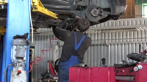 Mechanic service man work on car brake system and rusty brake disk. Tilt down. Stock Footage 64237461