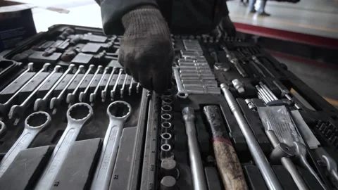 A mechanic at a service station puts the tool back into the toolbox. Stock Footage 154338944