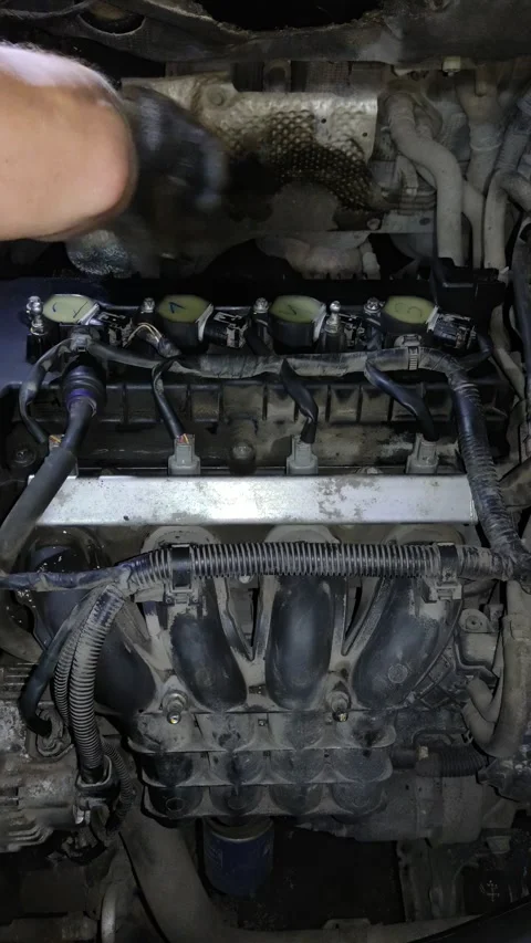 Mechanic servicing car engine in workshop setting in natural light Stock Footage 346638152
