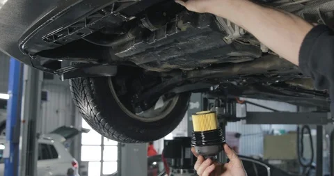 Mechanic Sets New Oil Filter Into The Car's Engine Video stock 124963153
