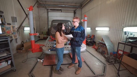 Mechanic showing customer the problem with car at the repair shop. Stock Footage 99211878
