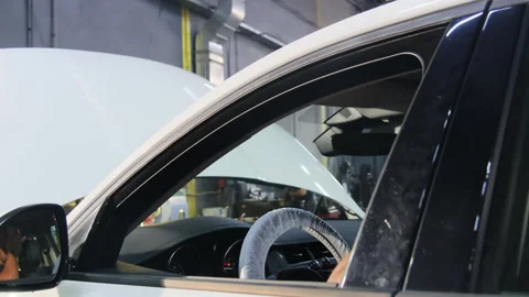 Mechanic sits inside modern car during repair process Video stock 317648668