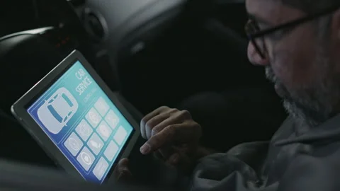 Mechanic Sitting in Car with Tablet and Working with Checkup Software Stock Footage 280321815